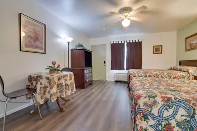 a hotel room with two beds and a table and a ceiling fan at Loveland Vacation Rental Pets Welcome in Loveland