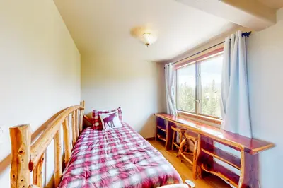 a bedroom with a bed and a window at The Retreat at Grand Lake in Grand Lake
