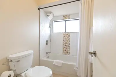 a bathroom with a toilet and a tub and a window at Lagoon Raven Townhome: Great Location, Amenities in Frisco
