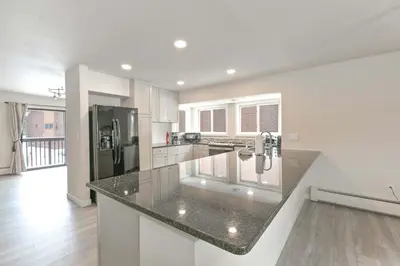 a kitchen with white cabinets and a black counter top at Lagoon Raven Townhome: Great Location, Amenities in Frisco