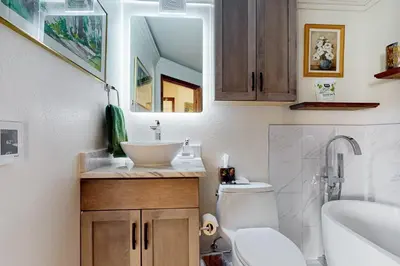 a bathroom with a sink and a toilet and a mirror at Frisco Home Base in Frisco
