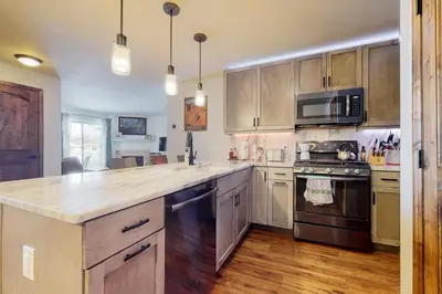 a kitchen with stainless steel appliances and wooden cabinets at Frisco Home Base in Frisco