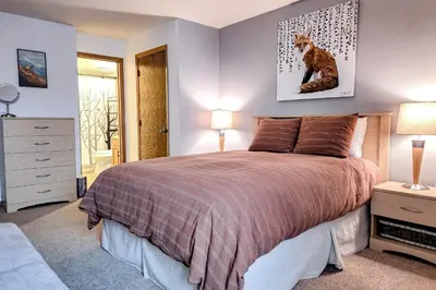 a bedroom with a bed with a cat picture on the wall at Griffons Nest in Silverthorne