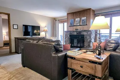 a living room with two leather couches and a fireplace at Griffons Nest in Silverthorne
