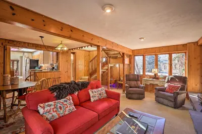 a living room with a red couch and a kitchen at 5 Mi to Dtwn Denver Peaceful Lakewood Home! in Lakewood