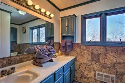 a bathroom with two sinks and a large mirror at 5 Mi to Dtwn Denver Peaceful Lakewood Home! in Lakewood