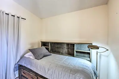 a bedroom with a bed with a wooden headboard at 5 Mi to Dtwn Denver Peaceful Lakewood Home! in Lakewood
