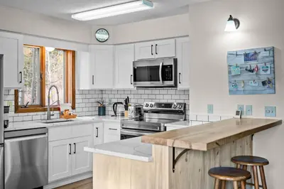 a kitchen with white cabinets and stainless steel appliances at 265 Forest Trail in Winter Park