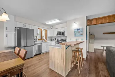 an open kitchen and living room with white cabinets at 265 Forest Trail in Winter Park