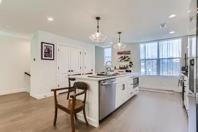 a kitchen with white cabinets and a table and a chair at 5419 Allison St, Unit G in Arvada