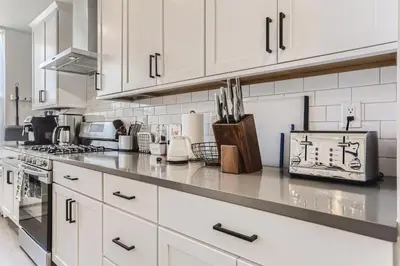 a kitchen with white cabinets and a counter top at 5419 Allison St, Unit G in Arvada