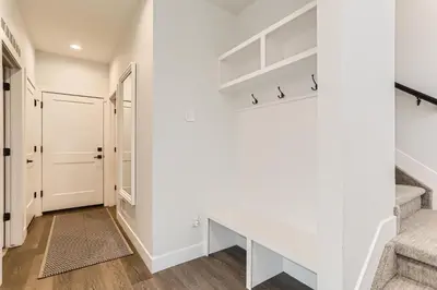 a hallway with stairs and white walls and a white door at 5419 Allison St, Unit G in Arvada