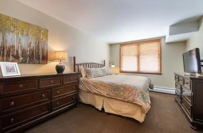 a bedroom with a bed and a dresser and a television at Zephyr Mountain Lodge, Condo - 3 Bedroom Select-Rated Condo 1609 condo in Winter Park