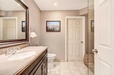 a bathroom with a sink and a toilet and a mirror at Denver Townhome in Highlands with Spacious Yard! in Denver