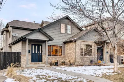 a house with a blue door in the snow at Denver Townhome in Highlands with Spacious Yard! in Denver