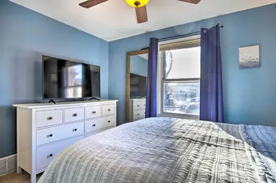 a bedroom with a bed and a tv and a window at Less Than 1 Mi to Empower Field Denver Vacation Rental in Denver