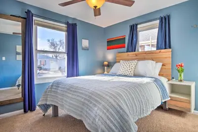 a blue bedroom with a bed and a window at Less Than 1 Mi to Empower Field Denver Vacation Rental in Denver