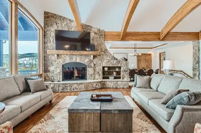 a living room with a large stone fireplace at NEW LISTING! Après & Fairway Retreat home in Breckenridge
