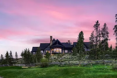 a house on a hill with a sunset at NEW LISTING! Après & Fairway Retreat home in Breckenridge