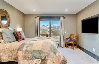 a bedroom with a bed and a large window at Moose Den Luxury Vacation Home at Windcliff home in Estes Park