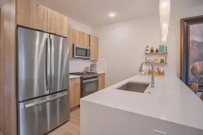 a kitchen with a stainless steel refrigerator and a sink at Cozy- Mountain Style - River View apartment - Colorado in Silverthorne
