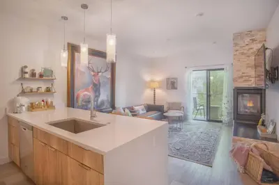 a kitchen with a sink and a living room at Cozy- Mountain Style - River View apartment - Colorado in Silverthorne