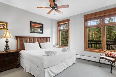 a bedroom with a bed with a ceiling fan and windows at Lone Eagle 3017 in Keystone