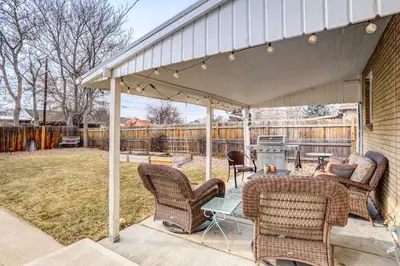 a covered patio with chairs and a table and a grill at Near Denver Zoo Home with Furnished Patio! in Denver