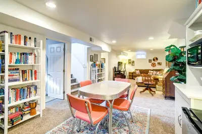 a dining room with a table and orange chairs at Near Denver Zoo Home with Furnished Patio! in Denver