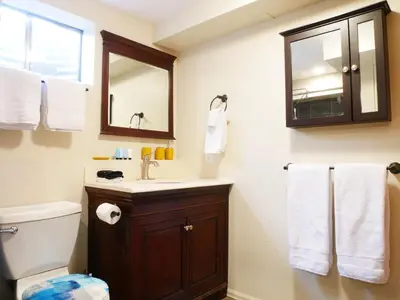 a bathroom with a toilet and a sink and a mirror at Private Basement, Bath, Living Area In Morrison in Morrison