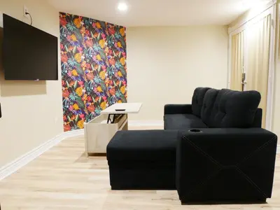 a living room with a black couch and a tv at Private Basement, Bath, Living Area In Morrison in Morrison