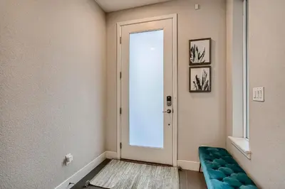 a hallway with a door and a blue chair at Stylish & Spacious Centrally-Located Home w/Garage in Wheat Ridge
