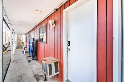 a red building with a door and a tv on a sidewalk at Loveland Vacation Rental - 1 Mile to Lake! in Loveland