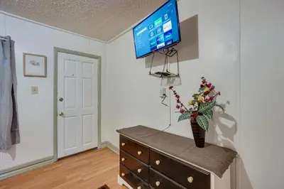 a room with a dresser with a television on a wall at Pet-Friendly Loveland Studio Near Boyd Lake! in Loveland