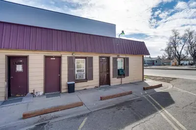 a small building with purple doors in a parking lot at Pet-Friendly Loveland Studio Near Boyd Lake! in Loveland
