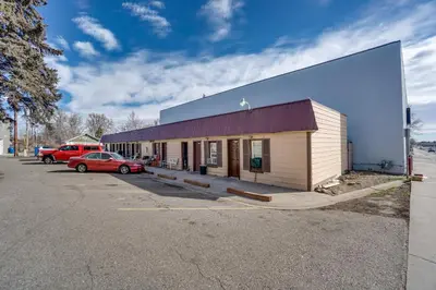 a building with a car parked in a parking lot at Pet-Friendly Loveland Studio Near Boyd Lake! in Loveland