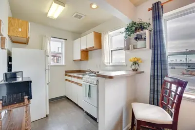 a kitchen with a white refrigerator and a chair at Loveland Vacation Rental Near Downtown! in Loveland