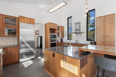 a kitchen with wooden cabinets and a stainless steel refrigerator at Modern Alpine Escape in Breckenridge