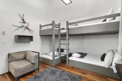 a bedroom with two bunk beds and a chair at Modern Alpine Escape in Breckenridge