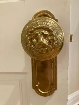 a gold door knocker with a face on a wall at Pineapple House, Spacious 1st Floor Apartment! City Center! 96 Walk Score! FREE parking! in Denver