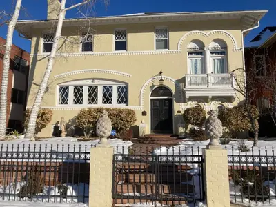 a house with a fence in front of it at Pineapple House, Spacious 1st Floor Apartment! City Center! 96 Walk Score! FREE parking! in Denver