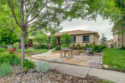 a backyard with a table and bench in front of a house at Shared Patio and Fire Pit Denver Apartment in Denver