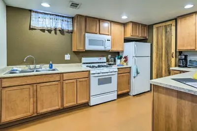 a kitchen with white appliances and wooden cabinets at Shared Patio and Fire Pit Denver Apartment in Denver
