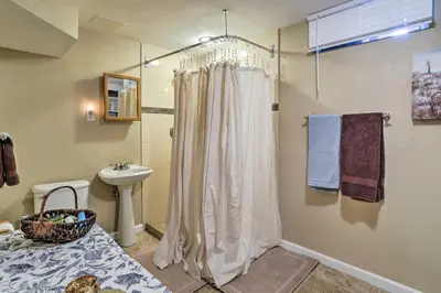 a bathroom with a shower curtain and a sink at Shared Patio and Fire Pit Denver Apartment in Denver