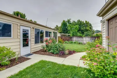 a house with a driveway and a yard with flowers at Shared Patio and Fire Pit Denver Apartment in Denver