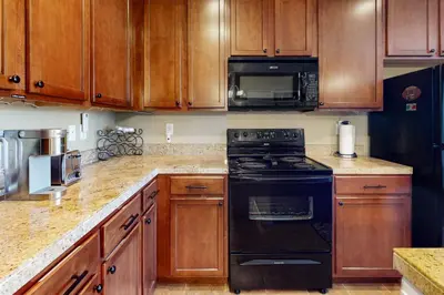a kitchen with wooden cabinets and a black stove top oven at The Great Granby Getaway in Granby