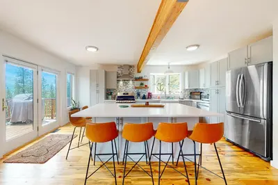 a kitchen with a large island with orange bar stools at Rainbow Connection in Tabernash