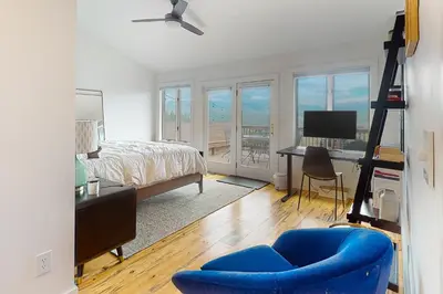 a bedroom with a blue chair and a bed and a desk at Rainbow Connection in Tabernash
