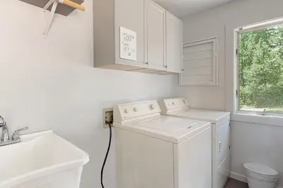 a white laundry room with a washing machine and a sink at Rainbow Connection in Tabernash