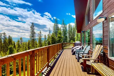 a balcony with chairs and a view of the forest at Rainbow Connection in Tabernash